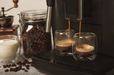 Mutfak masasında fincan olan modern kahve makinesi. Kahve evi. Mutfakta fincanı olan bir kahve makinesi. Sıcak kokulu bir içecek hazırlıyorum. Metin için yer. Boşluğu kopyala.