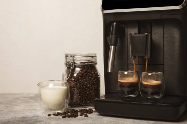 Mutfak masasında fincan olan modern kahve makinesi. Kahve evi. Mutfakta fincanı olan bir kahve makinesi. Sıcak kokulu bir içecek hazırlıyorum. Metin için yer. Boşluğu kopyala.