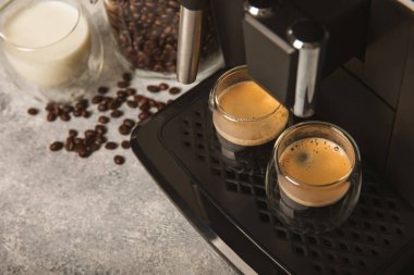 Mutfak masasında fincan olan modern kahve makinesi. Kahve evi. Mutfakta fincanı olan bir kahve makinesi. Sıcak kokulu bir içecek hazırlıyorum. Metin için yer. Boşluğu kopyala.