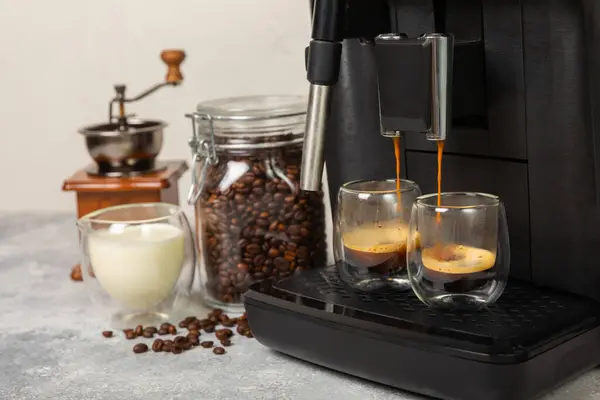 Mutfak masasında fincan olan modern kahve makinesi. Kahve evi. Mutfakta fincanı olan bir kahve makinesi. Sıcak kokulu bir içecek hazırlıyorum. Metin için yer. Boşluğu kopyala.