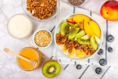 Bir kase granola yoğurt ve dokuma masasında taze böğürtlen. Yoğurt böğürtlen, acai kasesi, spirulina kasesi. Sağlıklı yemek, dengeli kahvaltı. Çilek, yabanmersini, kivi, şeftali, badem ve chia..