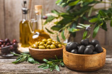 Beyaz ahşap arka planda siyah ve yeşil zeytin seti. Tahta kaselerde çeşitli zeytinler ve taze zeytin yaprakları. Uzayı kopyala Mesaj için yer. Düz lei. Lezzetli.