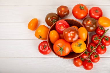 Mermer desenli domatesler. Çeri domatesleri, sarı, pembe, kahverengi ve siyah domatesler bir kasede. Organik sebzeler, hasat. Vejetaryen. Taze olgun domatesler. Boşluğu kopyala.