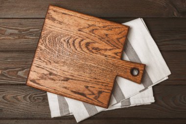 Mutfak masasının ahşap kesme tahtası. Ahşap mutfak tahtası ve mutfak havlusu. İmza. MOCKUP Mutfak eşyaları. Mesaj için yer. Uzayı kopyala Yemek tarifi. Yemek pişirme konsepti.