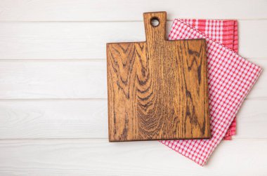 Mutfak masasının ahşap kesme tahtası. Ahşap mutfak tahtası ve mutfak havlusu. İmza. MOCKUP Mutfak eşyaları. Mesaj için yer. Uzayı kopyala Yemek tarifi. Yemek pişirme konsepti.