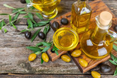 Kahverengi desenli bir şişede zeytin yağı. Zeytin dallı ve meyveli yağ şişesi. Mesaj için yer. kopyalama alanı. Yemek yağı ve salata sosu..