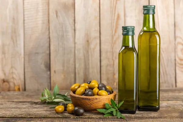 Olive oil in a bottle on brown texture background. Oil bottle with branches and fruits of olives. Place for text. copy space. cooking oil and salad dressing.