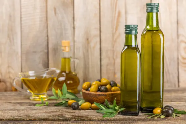 Olive oil in a bottle on brown texture background. Oil bottle with branches and fruits of olives. Place for text. copy space. cooking oil and salad dressing.