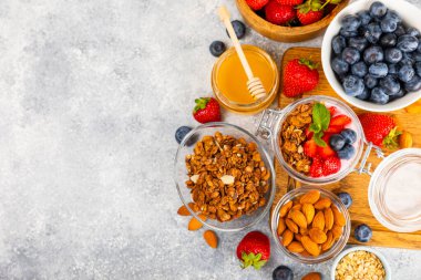 Granola kasesi. Yulaf ezmeli yoğurt, taze böğürtlen, spirulina ve chia çekirdeği. Sağlıklı yiyecekler. Lezzetli bir kahvaltı. Çilekli yoğurt, ahududu, yabanmersini, şeftali, nane ve mendal. Boşluğu kopyala.