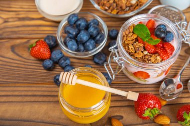 Granola kasesi. Yulaf ezmeli yoğurt, taze böğürtlen, spirulina ve chia çekirdeği. Sağlıklı yiyecekler. Lezzetli bir kahvaltı. Çilekli yoğurt, ahududu, yabanmersini, şeftali, nane ve mendal. Boşluğu kopyala.