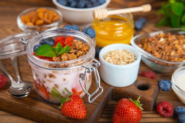 Granola kasesi. Yulaf ezmeli yoğurt, taze böğürtlen, spirulina ve chia çekirdeği. Sağlıklı yiyecekler. Lezzetli bir kahvaltı. Çilekli yoğurt, ahududu, yabanmersini, şeftali, nane ve mendal. Boşluğu kopyala.