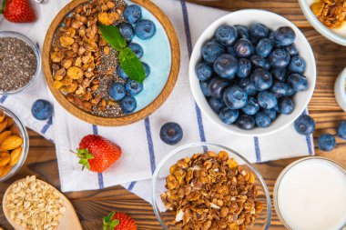 Granola kasesi. Yulaf ezmeli yoğurt, taze böğürtlen, spirulina ve chia çekirdeği. Sağlıklı yiyecekler. Lezzetli bir kahvaltı. Çilekli yoğurt, ahududu, yabanmersini, şeftali, nane ve mendal. Boşluğu kopyala.