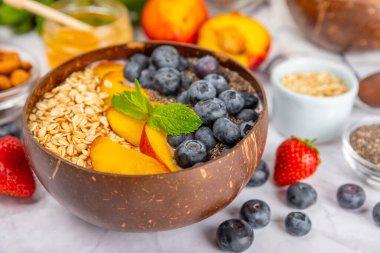 Granola kasesi. Yulaf ezmeli yoğurt, taze böğürtlen, spirulina ve chia çekirdeği. Sağlıklı yiyecekler. Lezzetli bir kahvaltı. Çilekli yoğurt, ahududu, yabanmersini, şeftali, nane ve mendal. Boşluğu kopyala.