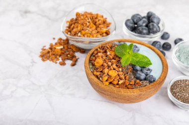 Granola kasesi. Yulaf ezmeli yoğurt, taze böğürtlen, spirulina ve chia çekirdeği. Sağlıklı yiyecekler. Lezzetli bir kahvaltı. Çilekli yoğurt, ahududu, yabanmersini, şeftali, nane ve mendal. Boşluğu kopyala.