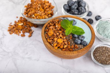 Granola kasesi. Yulaf ezmeli yoğurt, taze böğürtlen, spirulina ve chia çekirdeği. Sağlıklı yiyecekler. Lezzetli bir kahvaltı. Çilekli yoğurt, ahududu, yabanmersini, şeftali, nane ve mendal. Boşluğu kopyala.