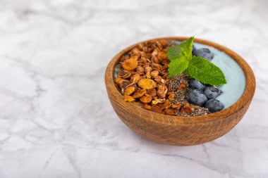 Granola kasesi. Yulaf ezmeli yoğurt, taze böğürtlen, spirulina ve chia çekirdeği. Sağlıklı yiyecekler. Lezzetli bir kahvaltı. Çilekli yoğurt, ahududu, yabanmersini, şeftali, nane ve mendal. Boşluğu kopyala.