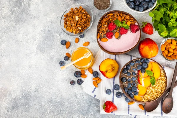 Granola bowl. Yogurt with oatmeal, fresh berries, spirulina and chia seeds. Healthly food. Tasty breakfast. Yogurt with strawberries, raspberries, blueberries, peaches, mint and mendal. Copy space.