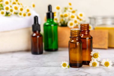 Papatya spası. Papatya çiçekleri, el yapımı sabun, temel yağ kozmetik şişesi, vücut kremi, ovalama ve beyaz desenli deniz tuzu karışımı. Rahatlatıcı güzellik tedavileri. Boşluğu kopyala