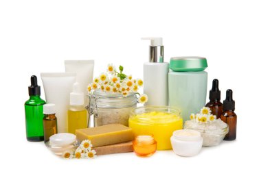 Papatya spası. Papatya çiçekleri, el yapımı sabun, temel yağ kozmetik şişesi, vücut kremi, ovalama ve beyaz arka planda izole edilmiş deniz tuzu bileşimi. Rahatlatıcı güzellik tedavileri.