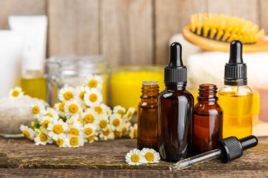 Papatya spası. Papatya çiçekleri, el yapımı sabun, temel yağ kozmetik şişesi, vücut kremi, ovalama ve beyaz desenli deniz tuzu karışımı. Rahatlatıcı güzellik tedavileri. Boşluğu kopyala