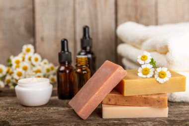Papatya spası. Papatya çiçekleri, el yapımı sabun, temel yağ kozmetik şişesi, vücut kremi, ovalama ve beyaz desenli deniz tuzu karışımı. Rahatlatıcı güzellik tedavileri. Boşluğu kopyala