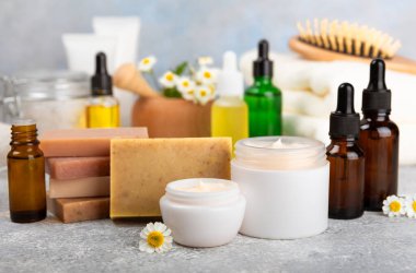 Papatya spası. Papatya çiçekleri, el yapımı sabun, temel yağ kozmetik şişesi, vücut kremi, ovalama ve beyaz desenli deniz tuzu karışımı. Rahatlatıcı güzellik tedavileri. Boşluğu kopyala