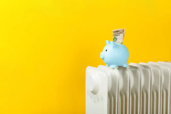 储蓄概念 钱在黄色墙壁背景的散热器上的储蓄罐里 加热季节的概念 冬季寒冷季节取暖费用昂贵和能源价格上涨的概念 — 图库照片