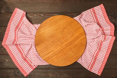 Ahşap mutfak masasında havlunun üzerinde tahta kesme tahtası. Çimento arka planında kesme tahtası ve mutfak havlusu. Menü yemek kartı ya da yemek tarifleri arka plan kavramı. MOCKUP Tasarım. Metin için yer, kopyalama alanı.