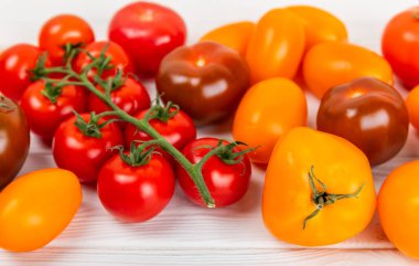 Mermer desenli domatesler. Çeri domatesleri, sarı, pembe, kahverengi ve siyah domatesler bir kasede. Organik sebzeler, hasat. Vejetaryen. Taze olgun domatesler. Boşluğu kopyala.