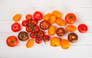 Mermer desenli domatesler. Çeri domatesleri, sarı, pembe, kahverengi ve siyah domatesler bir kasede. Organik sebzeler, hasat. Vejetaryen. Taze olgun domatesler. Boşluğu kopyala.