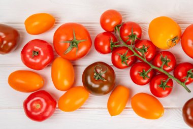 Mermer desenli domatesler. Çeri domatesleri, sarı, pembe, kahverengi ve siyah domatesler bir kasede. Organik sebzeler, hasat. Vejetaryen. Taze olgun domatesler. Boşluğu kopyala.