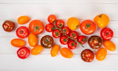 Mermer desenli domatesler. Çeri domatesleri, sarı, pembe, kahverengi ve siyah domatesler bir kasede. Organik sebzeler, hasat. Vejetaryen. Taze olgun domatesler. Boşluğu kopyala.