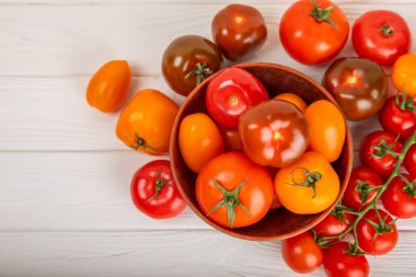 Mermer desenli domatesler. Çeri domatesleri, sarı, pembe, kahverengi ve siyah domatesler bir kasede. Organik sebzeler, hasat. Vejetaryen. Taze olgun domatesler. Boşluğu kopyala.