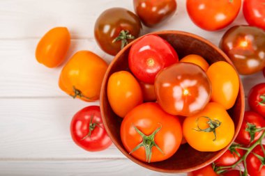 Mermer desenli domatesler. Çeri domatesleri, sarı, pembe, kahverengi ve siyah domatesler bir kasede. Organik sebzeler, hasat. Vejetaryen. Taze olgun domatesler. Boşluğu kopyala.