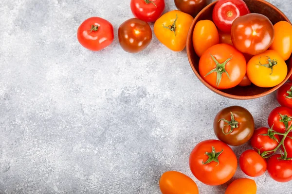 Mermer desenli domatesler. Çeri domatesleri, sarı, pembe, kahverengi ve siyah domatesler bir kasede. Organik sebzeler, hasat. Vejetaryen. Taze olgun domatesler. Boşluğu kopyala.