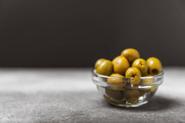 Dokulu arka planda yeşil ve siyah zeytin. Farklı türde zeytin ve taze zeytin yapraklı zeytin yağları. Lezzetli. Akdeniz mutfağı. Boşluğu kopyala.