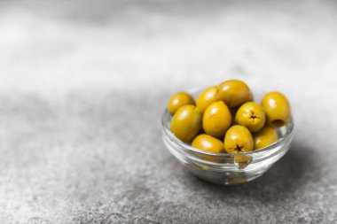 Dokulu arka planda yeşil ve siyah zeytin. Farklı türde zeytin ve taze zeytin yapraklı zeytin yağları. Lezzetli. Akdeniz mutfağı. Boşluğu kopyala.