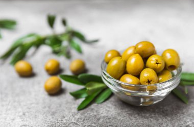 Dokulu arka planda yeşil ve siyah zeytin. Farklı türde zeytin ve taze zeytin yapraklı zeytin yağları. Lezzetli. Akdeniz mutfağı. Boşluğu kopyala.