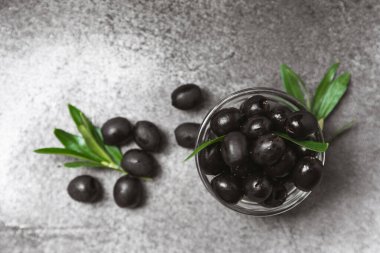 Dokulu arka planda yeşil ve siyah zeytin. Farklı türde zeytin ve taze zeytin yapraklı zeytin yağları. Lezzetli. Akdeniz mutfağı. Boşluğu kopyala.