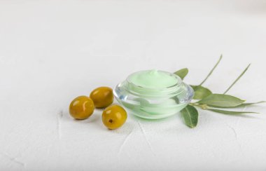 Bir kavanoz doğal zeytin kremi, zeytinyağı özü ve doku arkaplanı. Kozmetik tüpü. Cilt için nemlendirici kozmetik krem. Vücut bakımı. Güzellik konsepti. Uzayı kopyala Düz yatıyordu. El kremi.