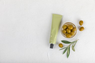 Bir kavanoz doğal zeytin kremi, zeytinyağı özü ve doku arkaplanı. Kozmetik tüpü. Cilt için nemlendirici kozmetik krem. Vücut bakımı. Güzellik konsepti. Uzayı kopyala Düz yatıyordu. El kremi.