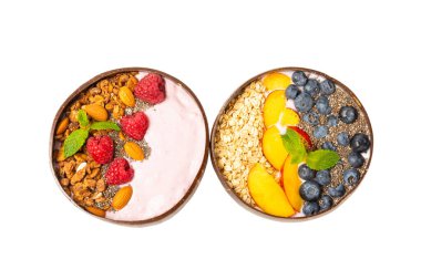 Beyaz arka planda yoğurt, taze badem, yaban mersini, ahududu, şeftali ve çilek içeren bir kase granola. Sağlıklı yiyecekler. dengeli kahvaltı.