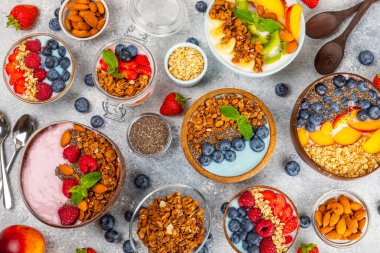 Bir kase granola yoğurt ve dokuma masasında taze böğürtlen. Yoğurt böğürtlen, acai kasesi, spirulina kasesi. Sağlıklı yemek, dengeli kahvaltı. Çilek, yabanmersini, kivi, şeftali, badem ve chia..