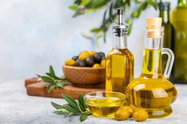 Doku arka planında bir şişe zeytinyağı. Zeytin dallı ve meyveli yağ şişesi. Mesaj için yer. kopyalama alanı. Yemek yağı ve salata sosu..