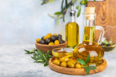 Doku arka planında bir şişe zeytinyağı. Zeytin dallı ve meyveli yağ şişesi. Mesaj için yer. kopyalama alanı. Yemek yağı ve salata sosu..