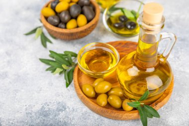 Doku arka planında bir şişe zeytinyağı. Zeytin dallı ve meyveli yağ şişesi. Mesaj için yer. kopyalama alanı. Yemek yağı ve salata sosu..