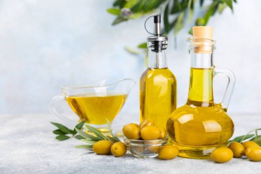 Doku arka planında bir şişe zeytinyağı. Zeytin dallı ve meyveli yağ şişesi. Mesaj için yer. kopyalama alanı. Yemek yağı ve salata sosu..