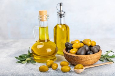 Doku arka planında bir şişe zeytinyağı. Zeytin dallı ve meyveli yağ şişesi. Mesaj için yer. kopyalama alanı. Yemek yağı ve salata sosu..