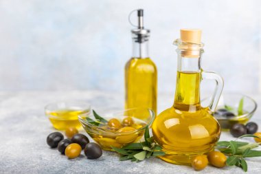 Doku arka planında bir şişe zeytinyağı. Zeytin dallı ve meyveli yağ şişesi. Mesaj için yer. kopyalama alanı. Yemek yağı ve salata sosu..