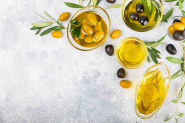 Doku arka planında bir şişe zeytinyağı. Zeytin dallı ve meyveli yağ şişesi. Mesaj için yer. kopyalama alanı. Yemek yağı ve salata sosu..